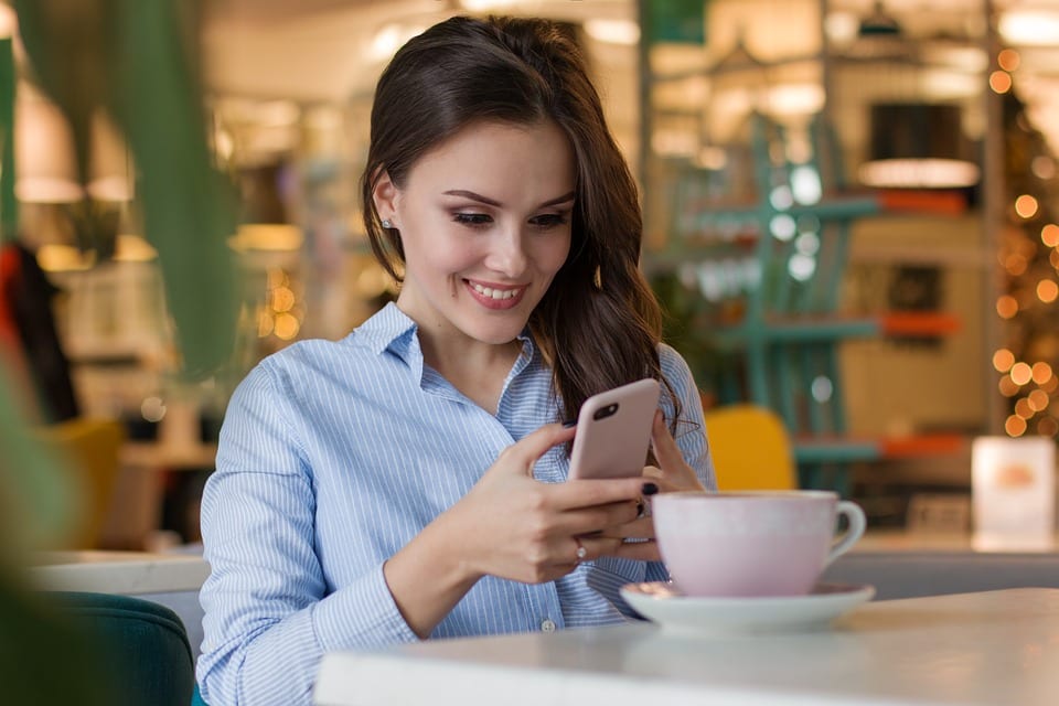 Woman on phone checking her contests to sell online products