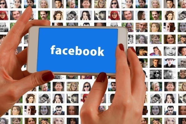 cell-phone-saying-facebook-and-photos-of-people-in-background