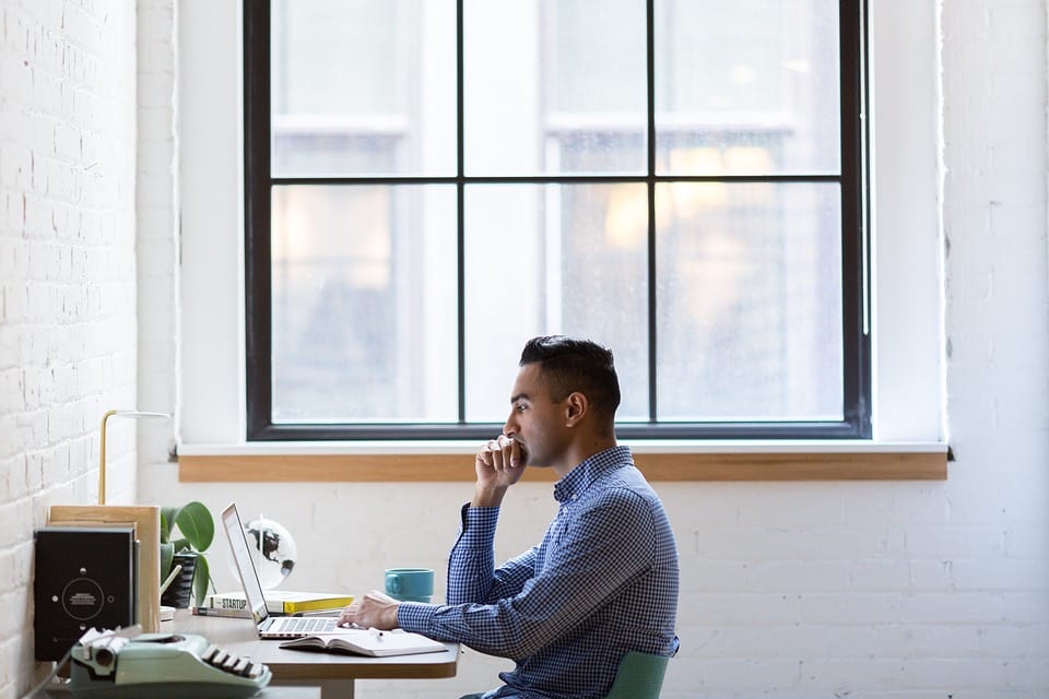 man-looking-at-laptop-in-office